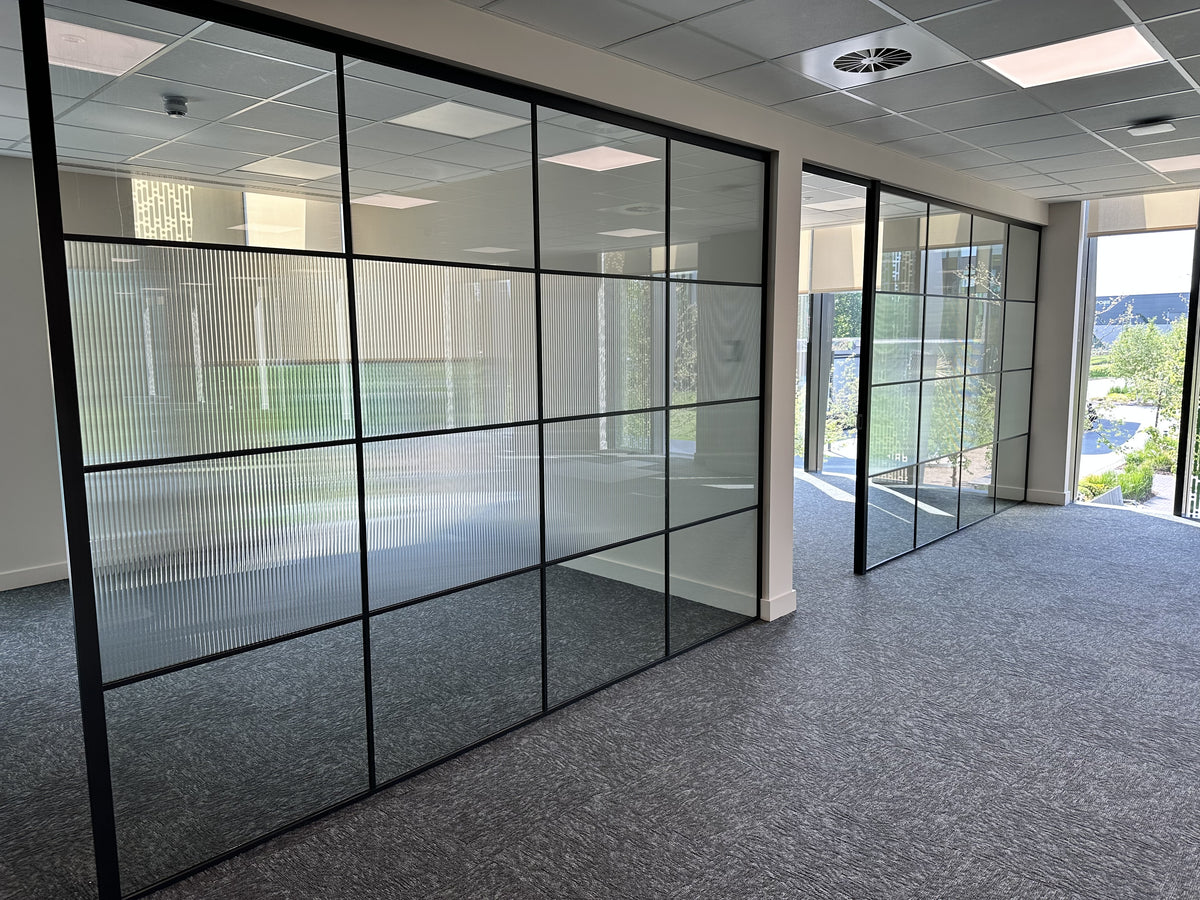 Reeded window film applied across the middle of two glazed offices for privacy.