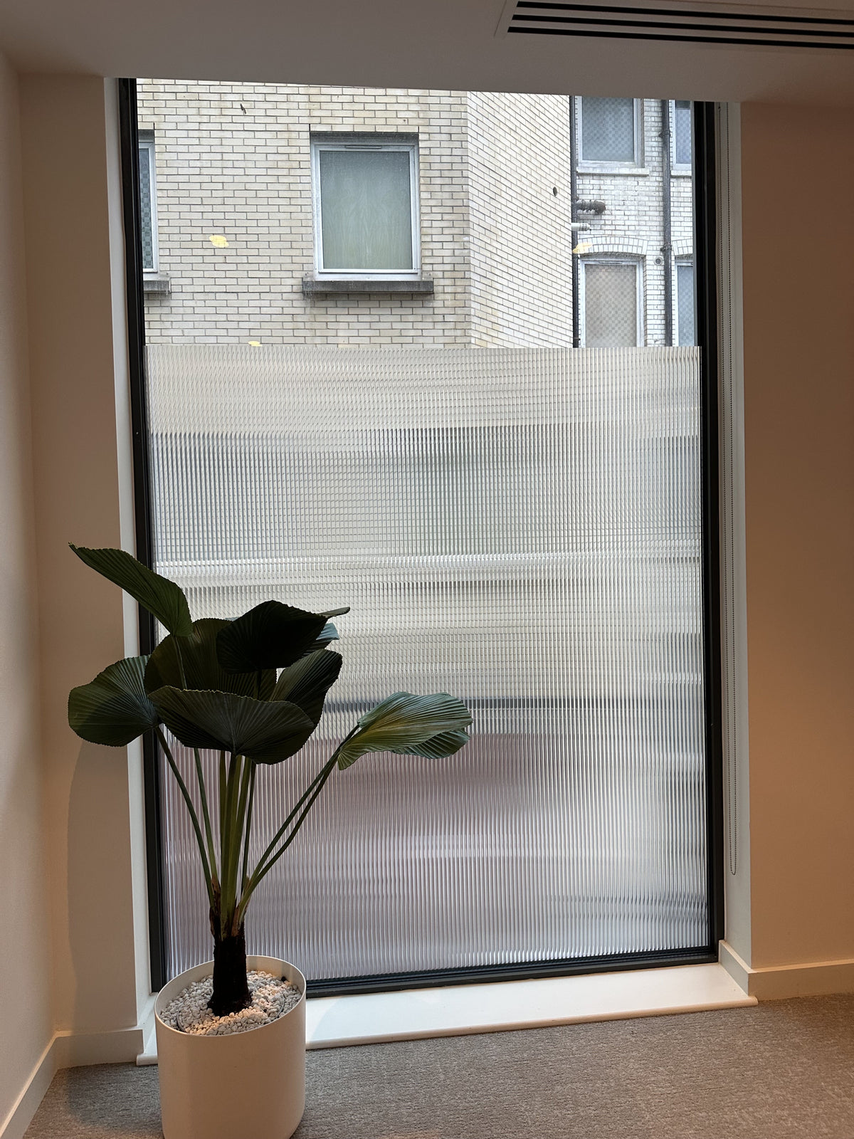 Reeded window film on a window to obscure vision but allow light through
