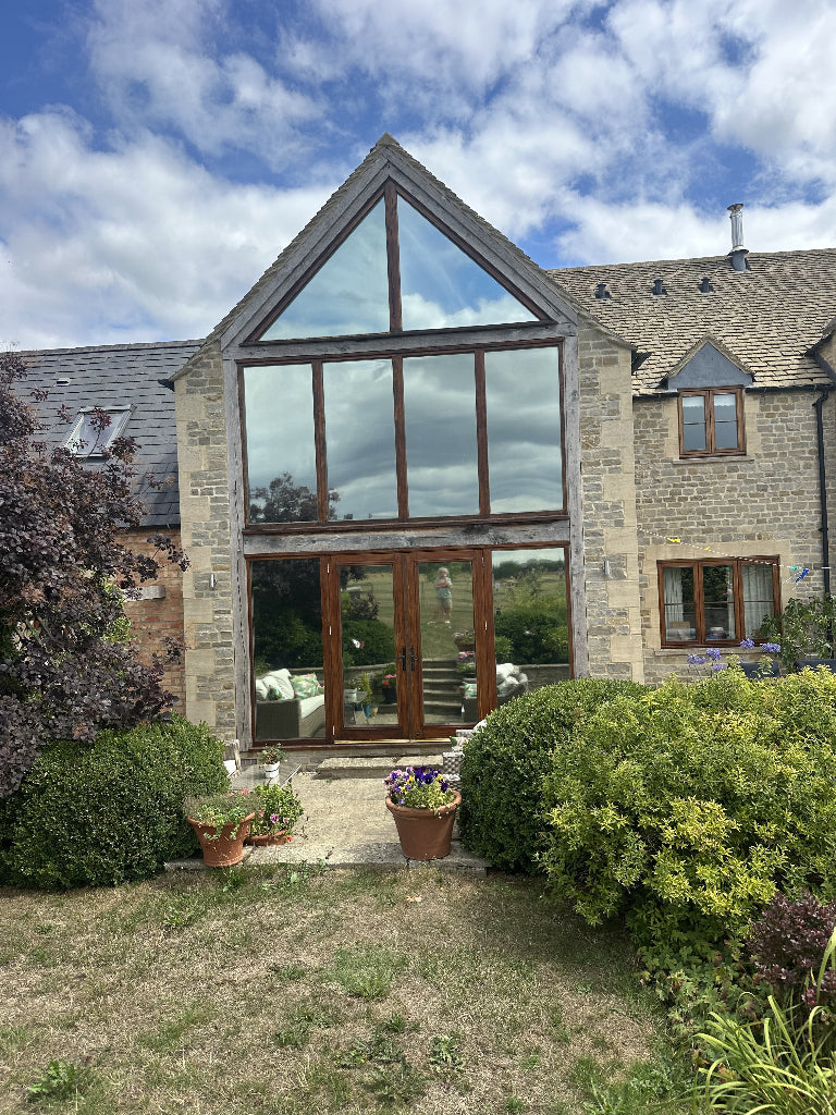 Outside of a house which has has solar film fitted to the shaped windows.