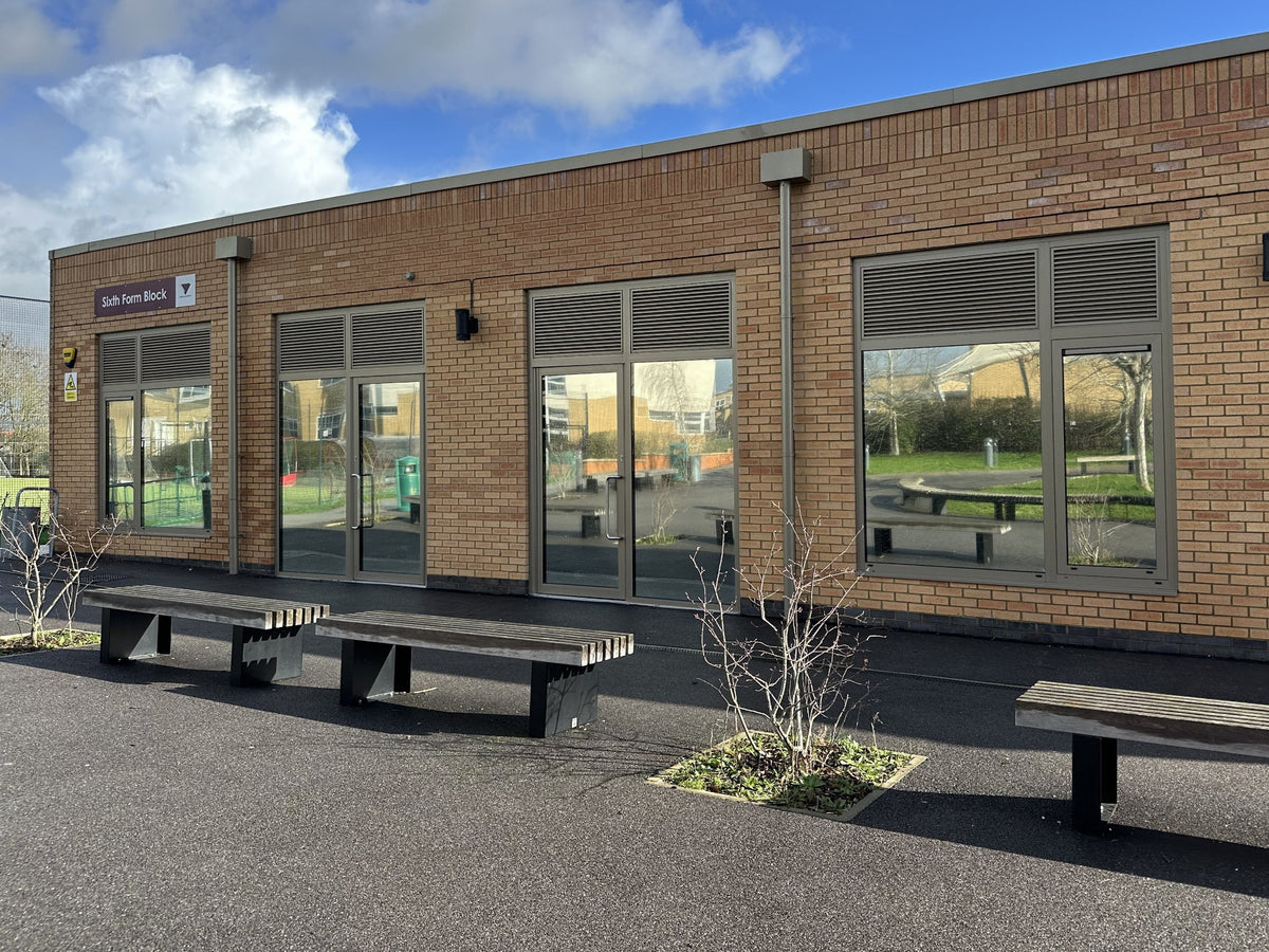 One-way solar control window film installed to large windows of a school classroom to reduce heat and glare.