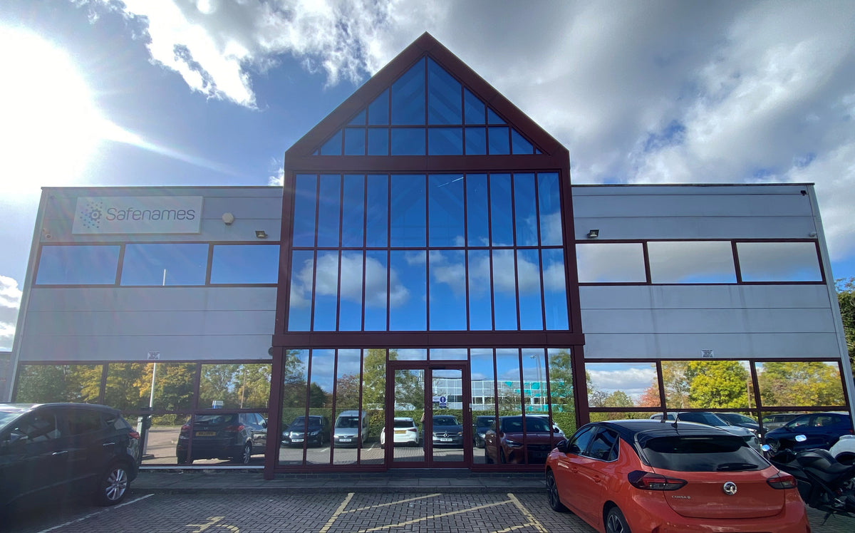 Modern building with large glass facade, with reflective heat reduction film applied to the shaped window at the front.