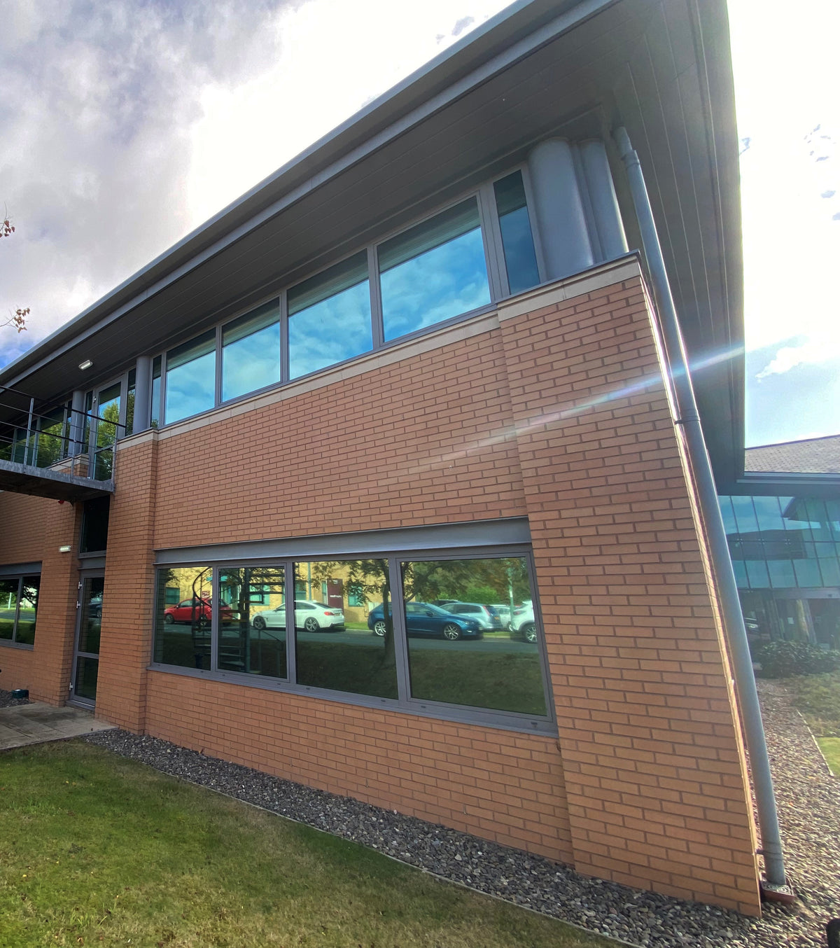 Corner of a brick building which has solar control window film applied to the windows to reduce heat and glare.