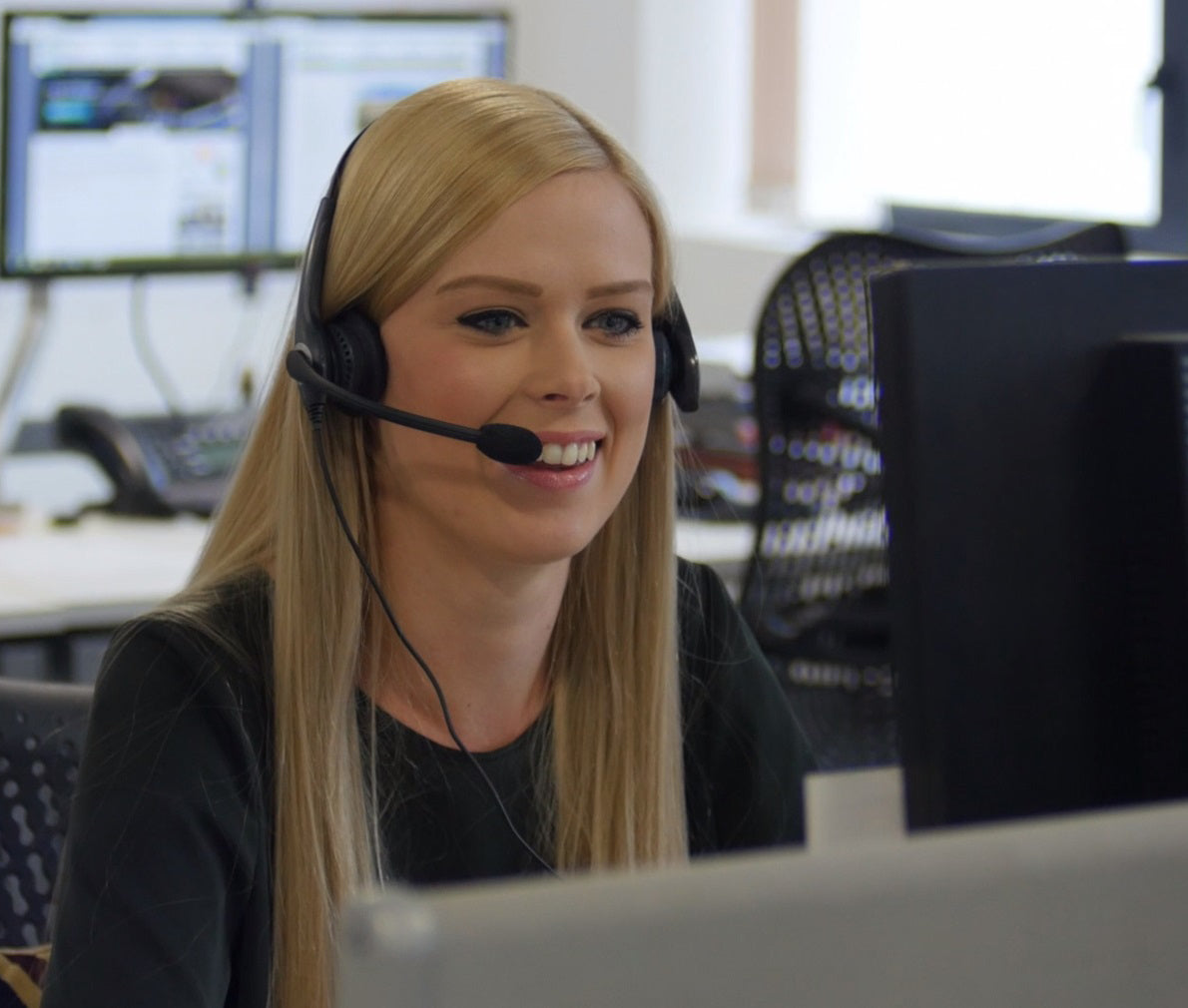 A smiling member of The Window Film Company's office staff takes a phone call. 
