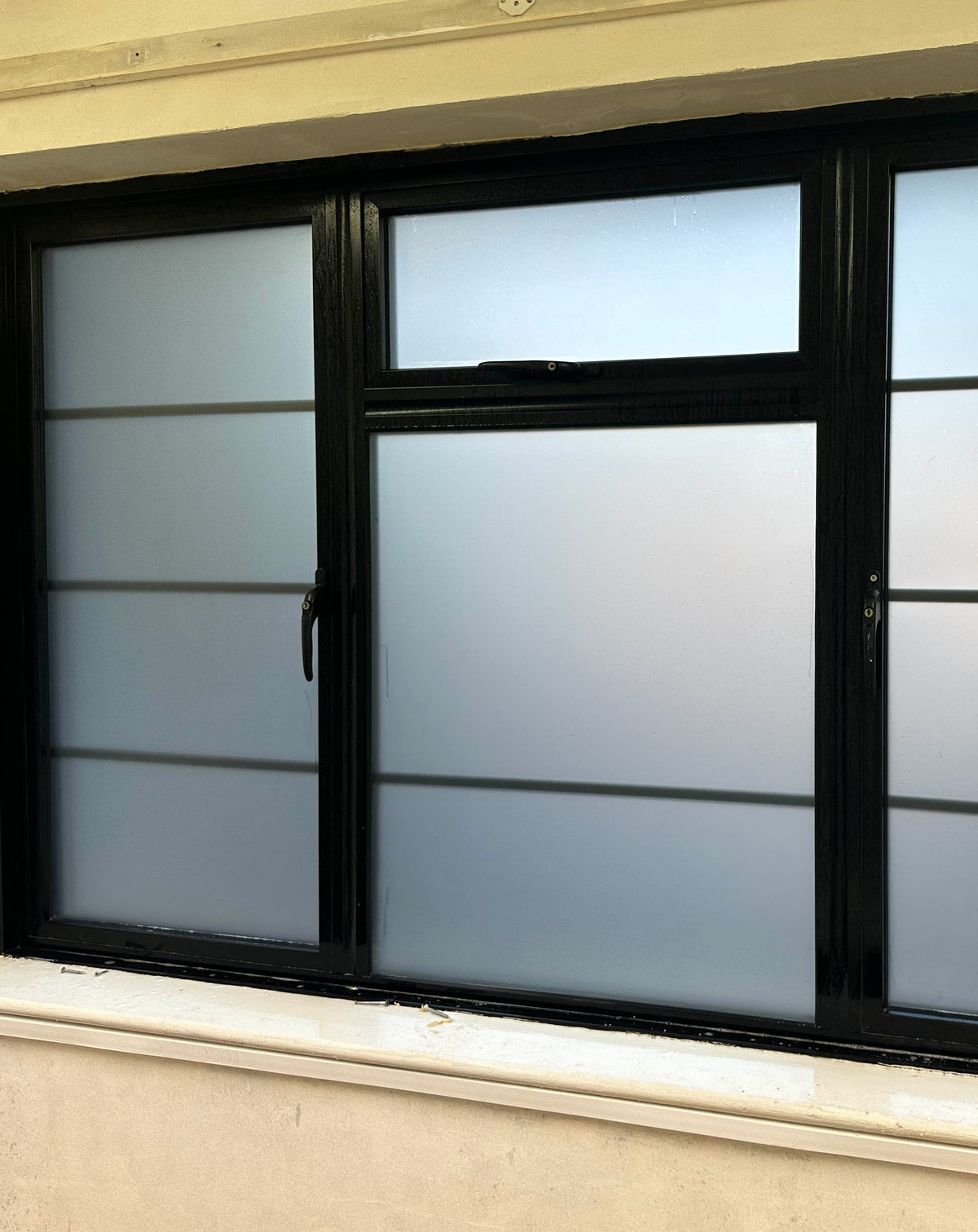An internal view of windows split into multiple panes, each with frosted window film applied to give the glass the appearance of frosted or acid etched glazing. 