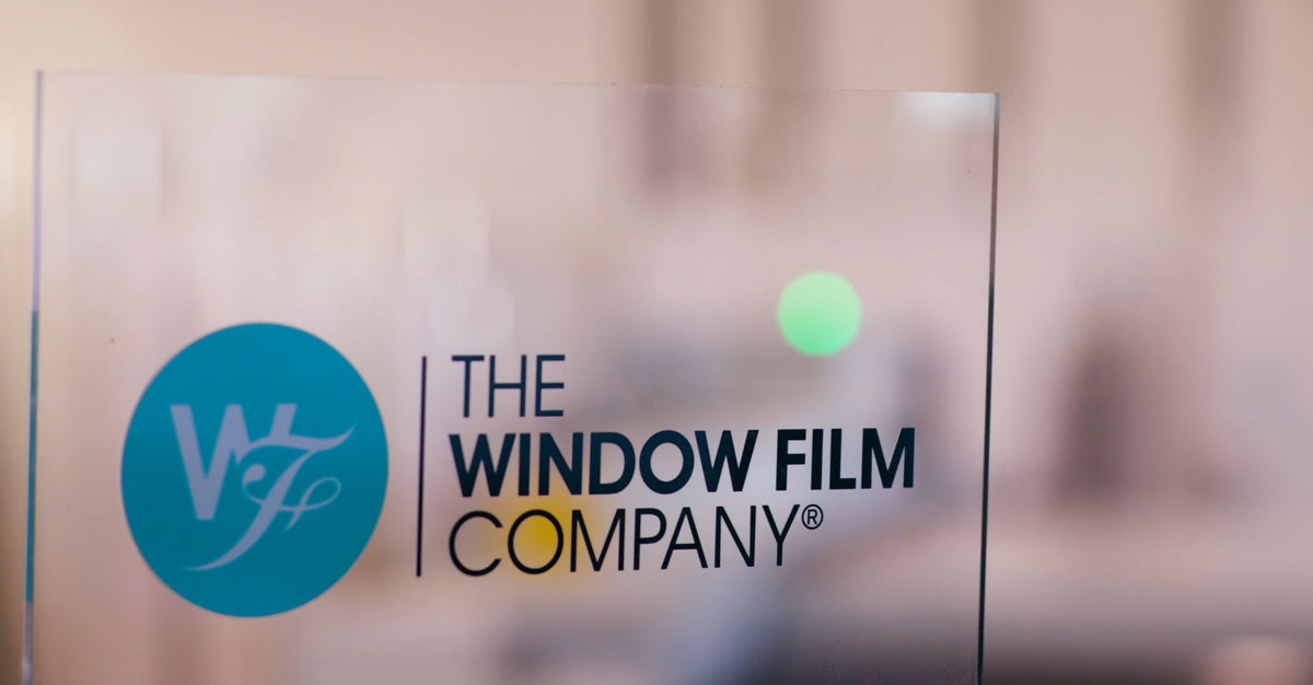 A close up of The Window Film Company's logo on glass.