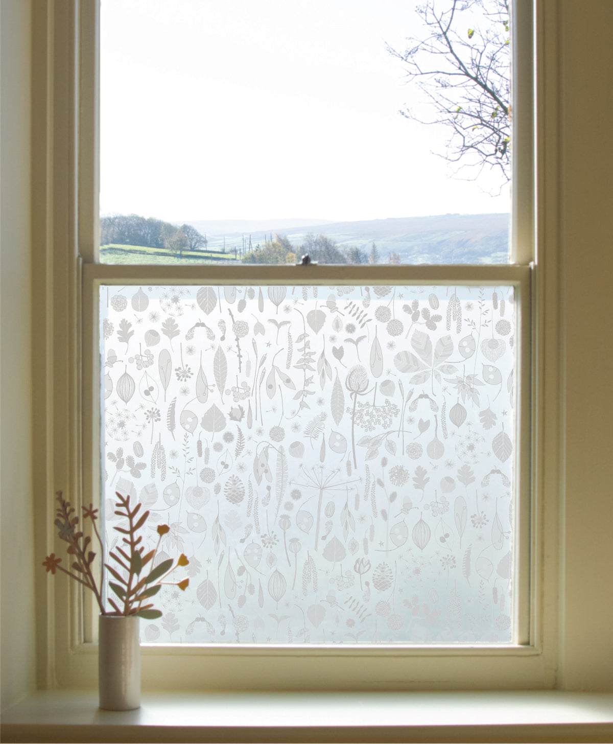 Window pane in a home featuring Tiny Treasures by Hannah Nunn window film applied to the lower pane.