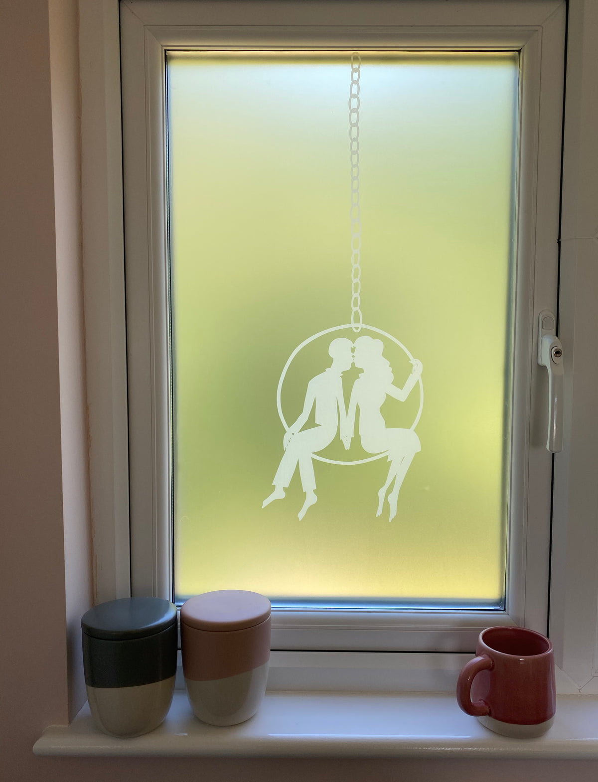 Window in a home with white frame, with frosted window film featuring a white printed Rob Ryan design