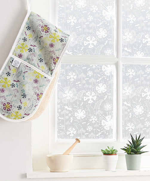 Close up of a window with white frames and a floral inspired frosted window film by Helen Russell applied to the glass. 