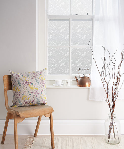 Room with white walls and a window with white frame, featuring Helen Russell white printed frosted window film applied to the glass.