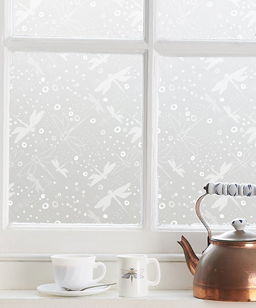 Close-up of window with white frame and white printed Helen Russell window film applied to the glass. 