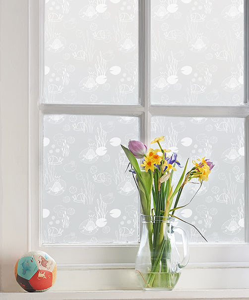 Close up of a window with a white wooden frame and Helen Russell designer frosted window film applied to the glass.
