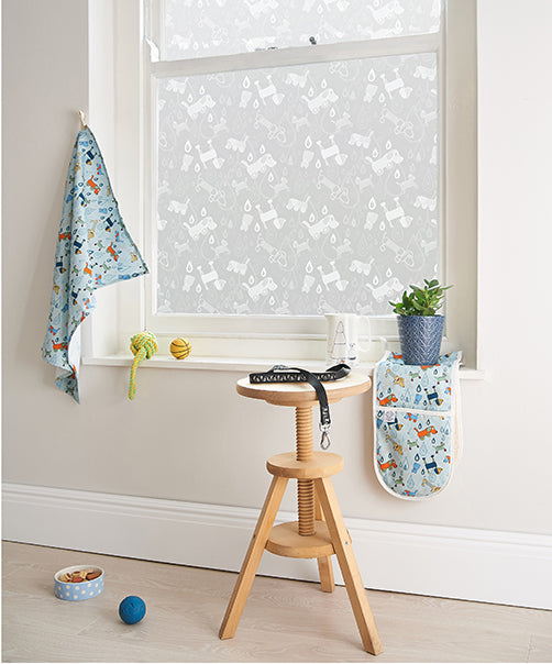 Contemporary room in a home with a wooden stool in the foreground and Helen Russell designed window film on the windows. 