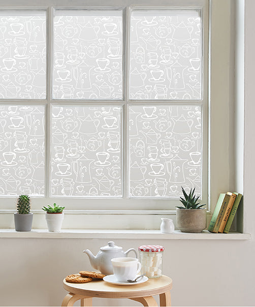 Internal view of a window split into multiple panes with white frames and a white printed Helen Russell creations window film applied to each pane. 