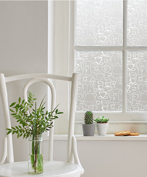 Window with white frames featuring a white printed Helen Russell window film applied to each pane. 