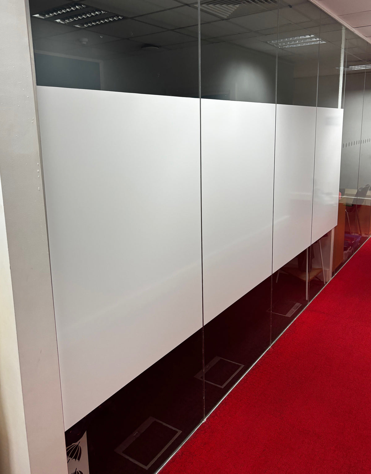 A glass partition with white whiteout privacy window film applied