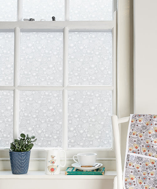 Close up of Birdie Folk window film by Helen Russell applied to a window in a contemporary home setting. 