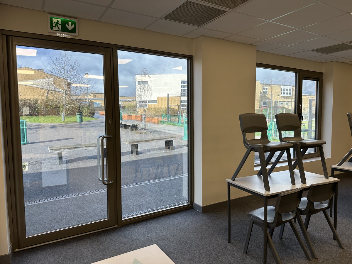 Inside a classroom which has had a solar control window film applied to the inside of the glass to reduce heat and glare.